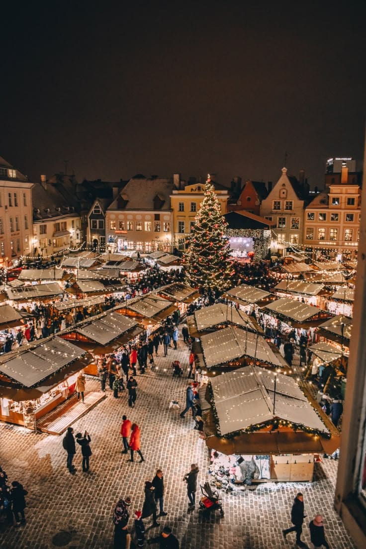 Ultimate Guide to the Tallinn Estonia Christmas Market A festive Christmas market at night with a large decorated tree and illuminated stalls crowded with people. | Sky Rye Design A festive Christmas market at night with a large decorated tree and illuminated stalls crowded with people.
