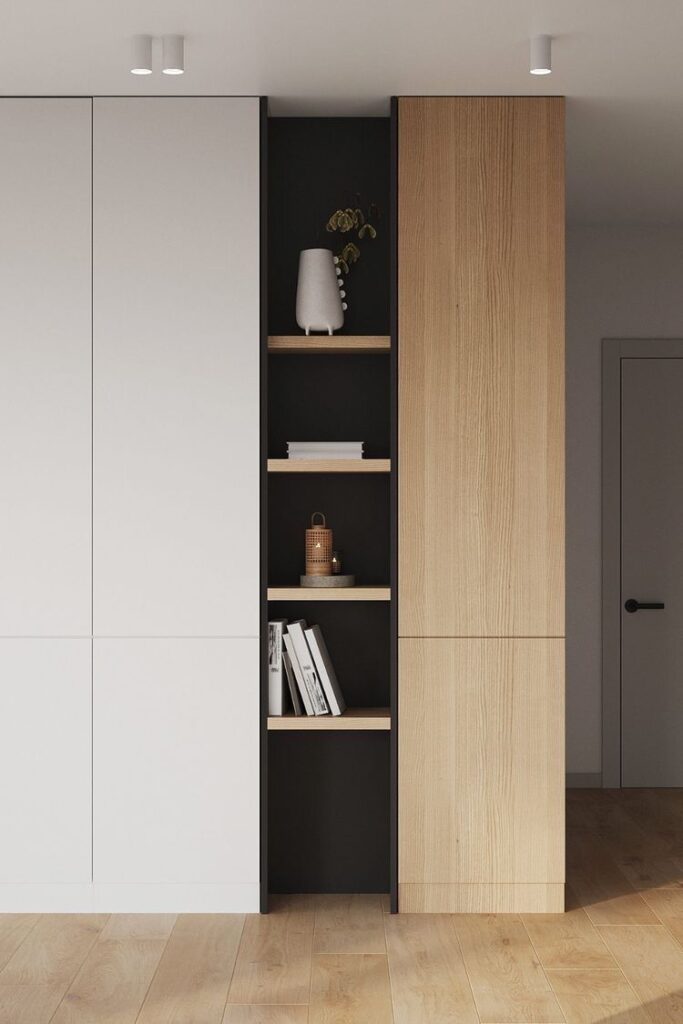 Minimalist shelving unit with books, vase, and decor on wooden floor in modern interior.