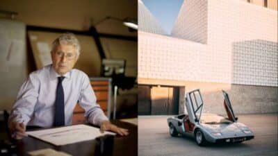 Designer at work with classic car featuring scissor doors parked outside modern building.