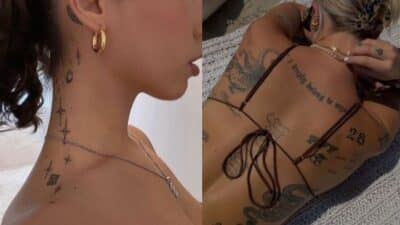 Person showcasing intricate neck and back tattoos in a stylish pose, wearing gold accessories and a bikini top.