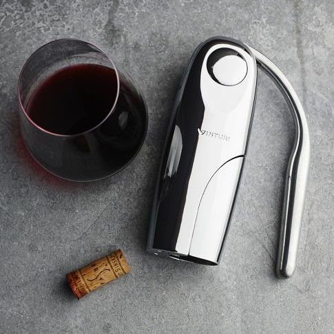 Vinturi Vertical Wine Opener Electric corkscrew with glass of red wine and cork on gray surface. | Sky Rye Design Electric corkscrew with glass of red wine and cork on gray surface.