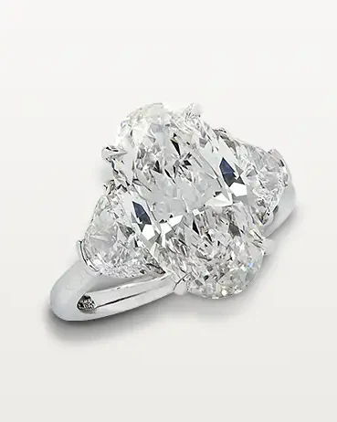 Vivid1 Elegant three-stone diamond engagement ring with oval-cut center and side diamonds on a platinum band. | Sky Rye Design Elegant three-stone diamond engagement ring with oval-cut center and side diamonds on a platinum band.