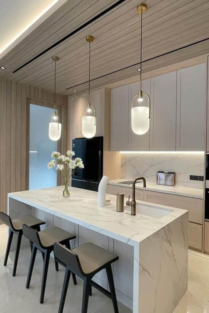 Modern kitchen with marble island, pendant lighting, and sleek cabinetry design.
