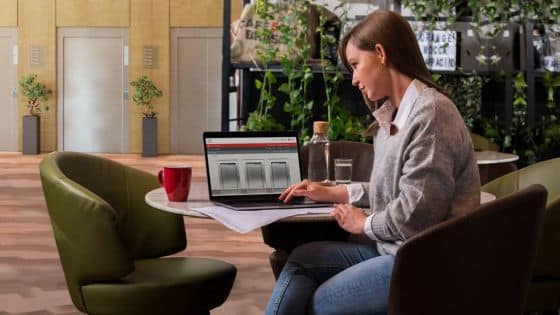 Why Every Needs an Elevator Escalator Planning Tool Woman working on a laptop in a modern cafe, surrounded by plants and coffee, focused on her task. | Sky Rye Design Woman working on a laptop in a modern cafe, surrounded by plants and coffee, focused on her task.
