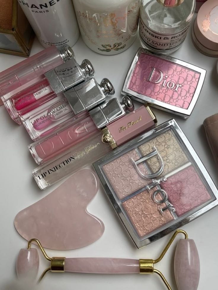 a dream Luxury makeup and skincare collection featuring lip glosses, blush, and a facial roller on a white background. | Sky Rye Design Luxury makeup and skincare collection featuring lip glosses, blush, and a facial roller on a white background.