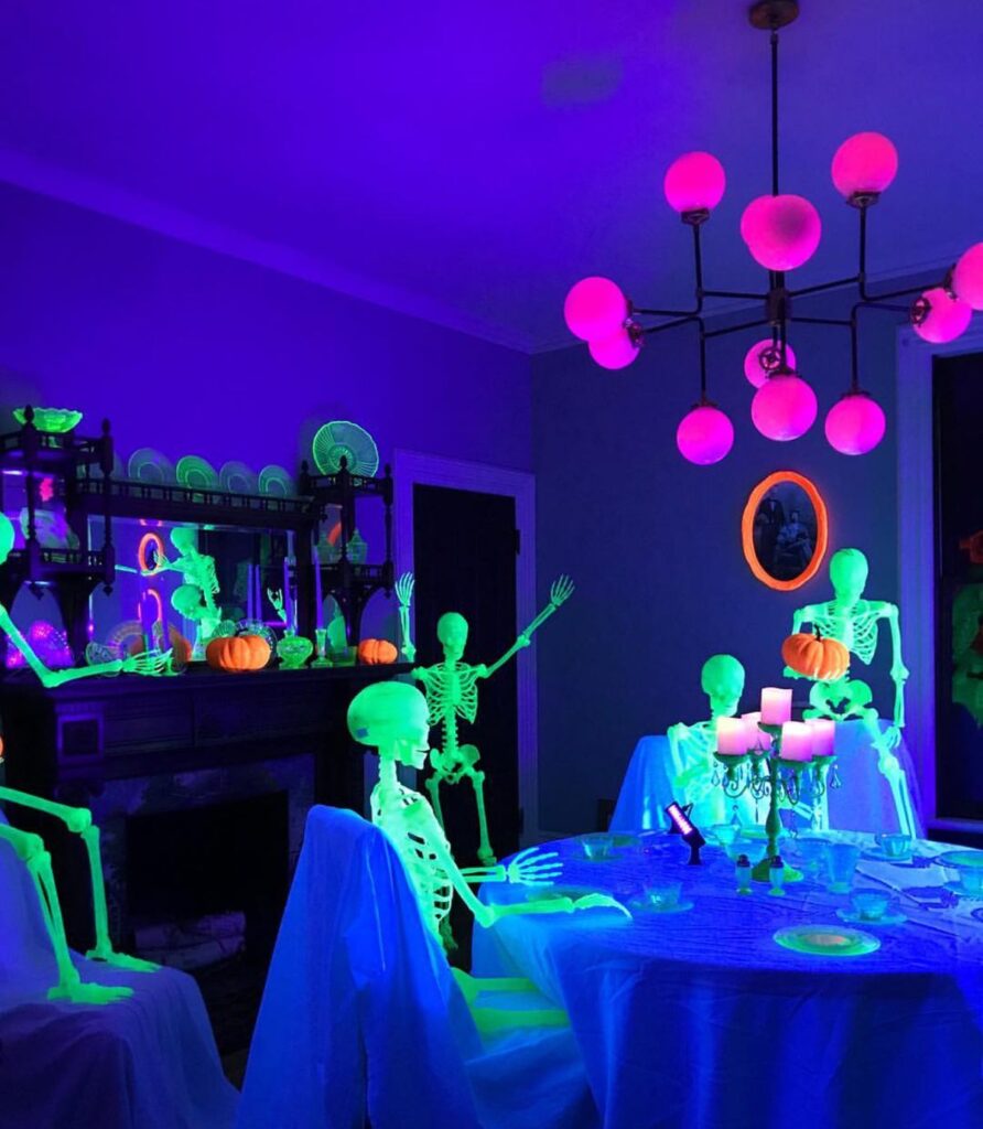 a9195d3f3f96288530731901e83689cc Glowing skeletons and pumpkins in a neon-lit Halloween dining room with vibrant pink chandelier. | Sky Rye Design Glowing skeletons and pumpkins in a neon-lit Halloween dining room with vibrant pink chandelier.