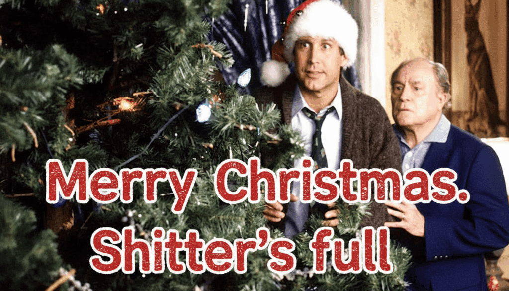 Two men in holiday attire by a Christmas tree, with humor text: Merry Christmas. Shitter's full.