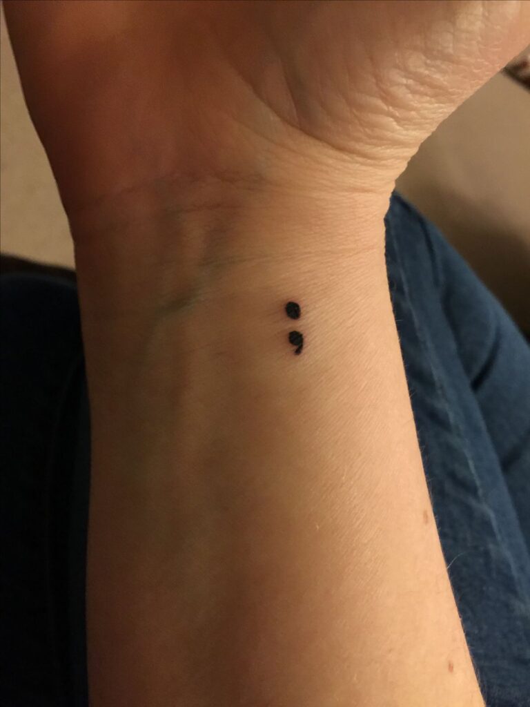 b3f0192caae5079c2f01ae01a24b020b Close-up of a wrist with a small semicolon tattoo, symbolizing hope and resilience. | Sky Rye Design Close-up of a wrist with a small semicolon tattoo, symbolizing hope and resilience.
