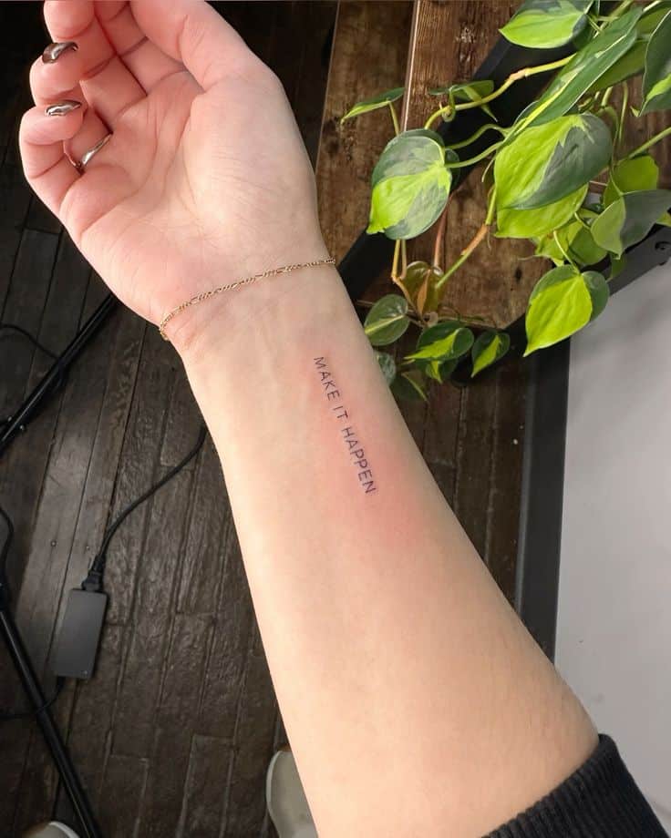 b46b273a5eab3b5717c8e48ce588fdea Tattoo of the phrase Make It Happen on inner forearm, with a background of green leaves and wooden floor. | Sky Rye Design Tattoo of the phrase Make It Happen on inner forearm, with a background of green leaves and wooden floor.