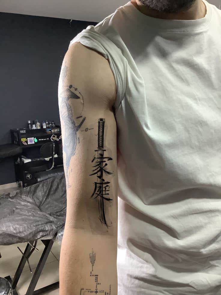 bcd900db-056a-4f78-a81b-b4fa575030f9 Arm tattoo with sword and Chinese characters, showcasing intricate design in a tattoo studio setting. | Sky Rye Design Arm tattoo with sword and Chinese characters, showcasing intricate design in a tattoo studio setting.