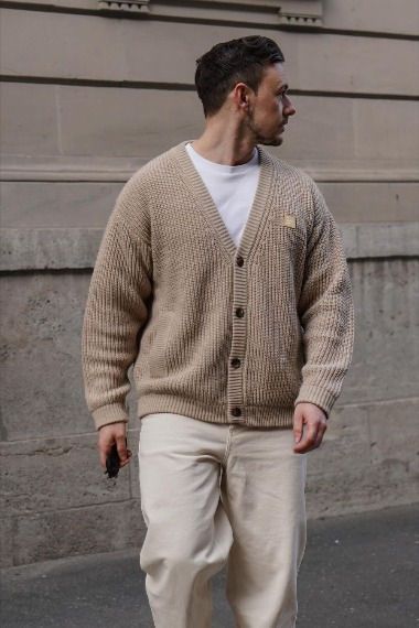 bf28ec65-d17e-4727-bba9-75cb7b49796c Man in beige cardigan and white pants walking on a city street. | Sky Rye Design Man in beige cardigan and white pants walking on a city street.