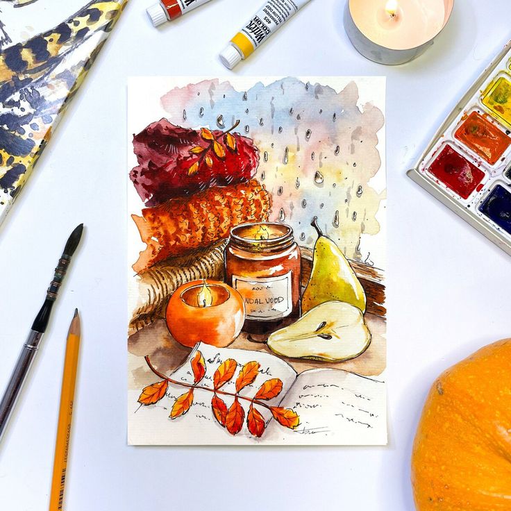 Autumn-themed watercolor painting with candles, fruit, and cozy textures, surrounded by art supplies.