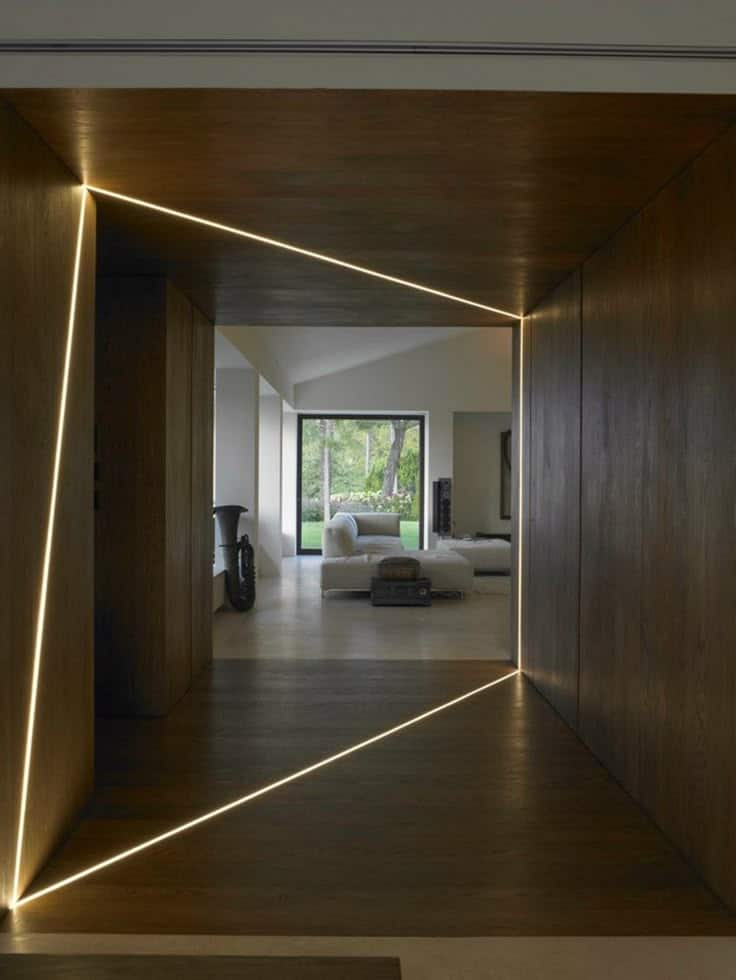 biophilic interior design inspiration_ mystery anooi studio Modern hallway with geometric lighting leading to a living room with large window and garden view. | Sky Rye Design Modern hallway with geometric lighting leading to a living room with large window and garden view.