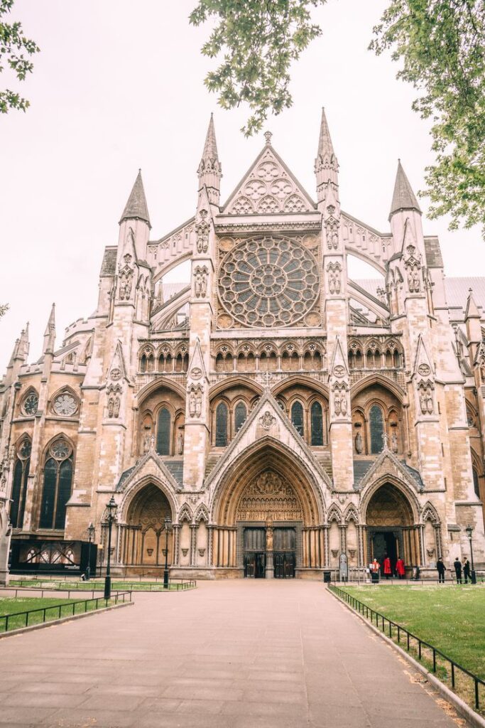 Gothic architecture of historic cathedral facade with detailed stonework and large rose window, framed by trees.