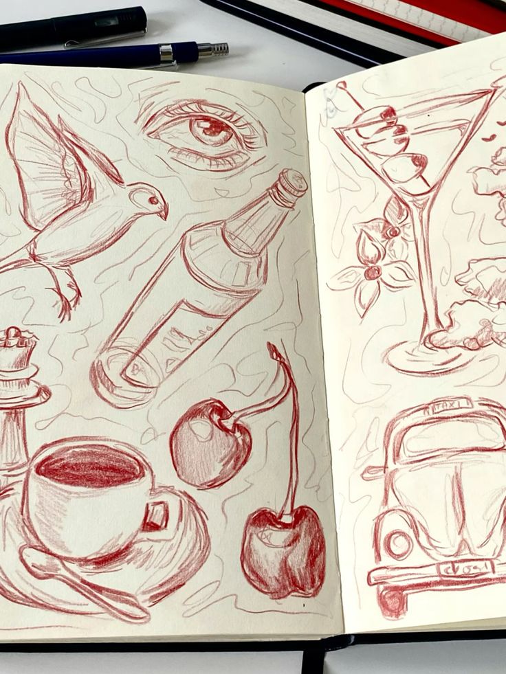 Sketchbook with red pencil doodles: bird, eye, bottle, martini, cherries, cup, and car. Artistic creativity theme.