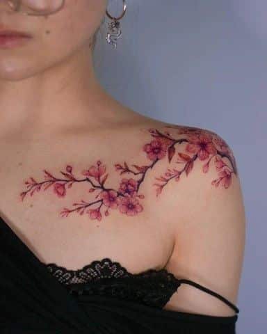 d521693d-b094-4eb1-8af7-ac4481093e8e Delicate cherry blossom tattoo on woman's shoulder, showcasing intricate floral design and elegant detailing. | Sky Rye Design Delicate cherry blossom tattoo on woman's shoulder, showcasing intricate floral design and elegant detailing.