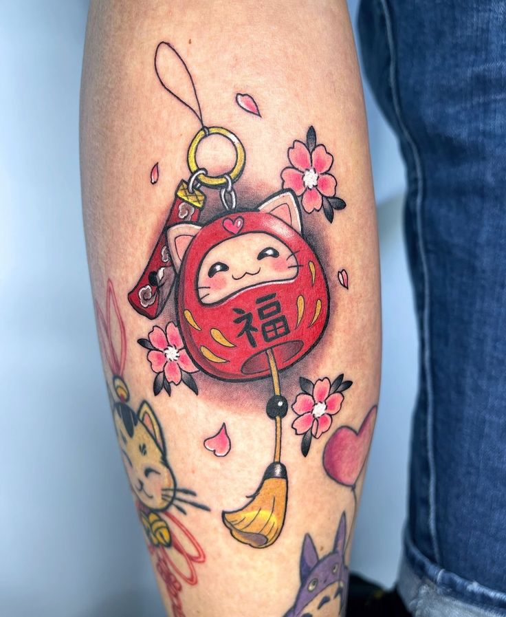 d6175ca7-ef8a-4f49-8cc7-af7402b0efbf Colorful tattoo of a lucky cat charm and cherry blossoms on an arm, symbolizing good fortune and harmony. | Sky Rye Design Colorful tattoo of a lucky cat charm and cherry blossoms on an arm, symbolizing good fortune and harmony.