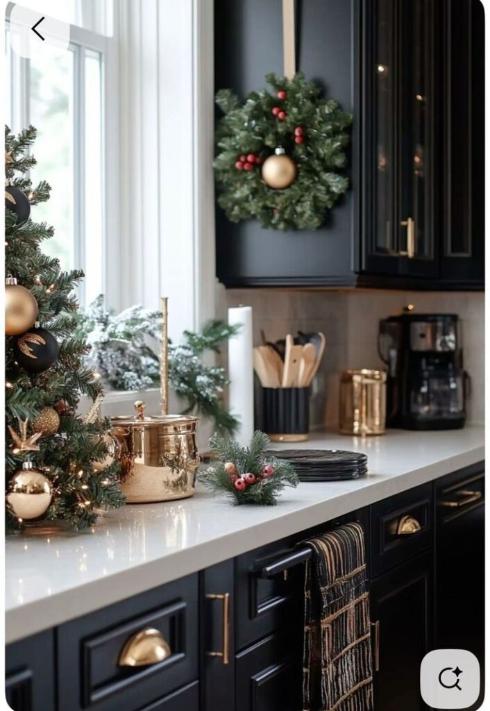 Festive kitchen decor with wreath and gold accents on black cabinets, perfect for a stylish holiday ambiance.