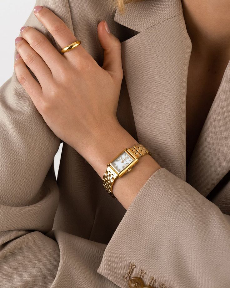 ddb43605-01e7-46b3-8801-ef04cb034023 Woman wearing a gold watch and ring with beige blazer. | Sky Rye Design Woman wearing a gold watch and ring with beige blazer.