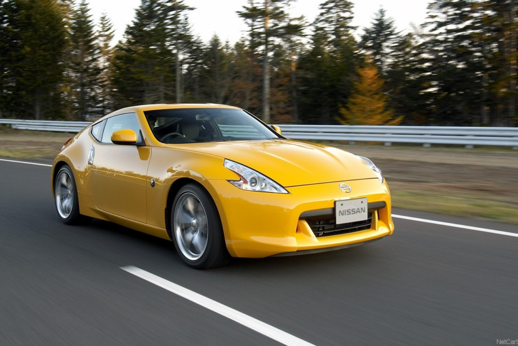 image Yellow Nissan 370Z sports coupe driving on a highway with blurred trees, high-performance sports car exterior | Sky Rye Design Yellow Nissan 370Z sports coupe driving on a highway with blurred trees, high-performance sports car exterior