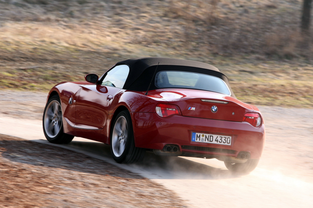 image Rear three-quarter view of red BMW Z4 M convertible kicking up dust on a winding country road | Sky Rye Design Rear three-quarter view of red BMW Z4 M convertible kicking up dust on a winding country road