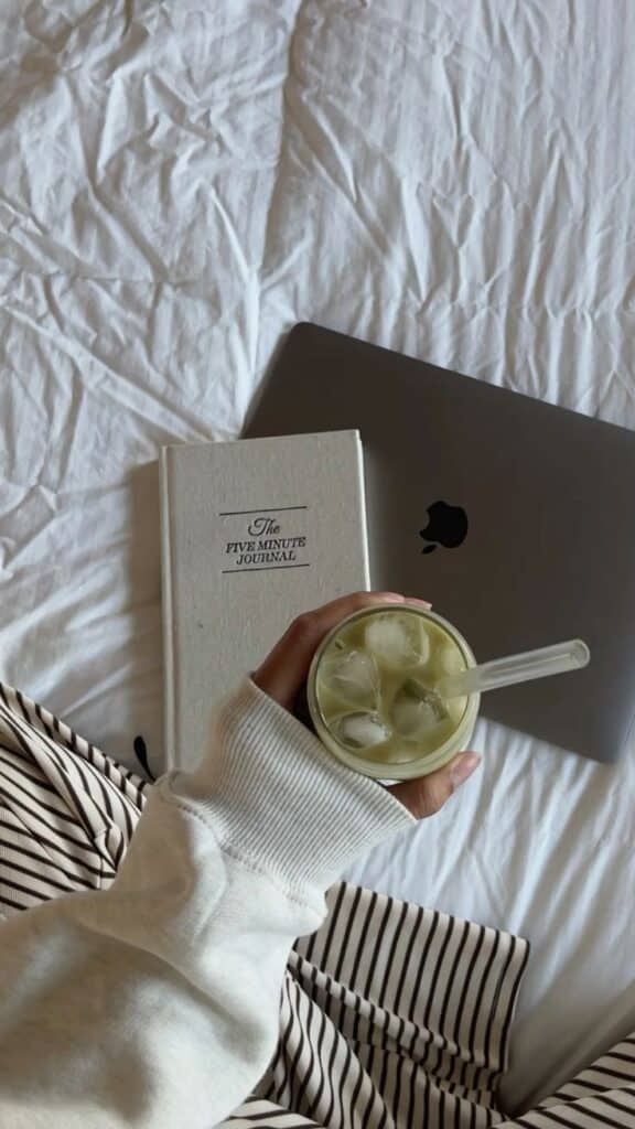 e769b6eb-fca9-47b3-99ba-7271c187ca09 Cozy setup with a journal, laptop, and iced matcha on a white bedspread. Perfect for productivity and relaxation. | Sky Rye Design Cozy setup with a journal, laptop, and iced matcha on a white bedspread. Perfect for productivity and relaxation.