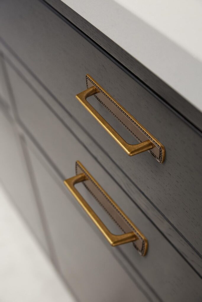 e7f1f4f87c682ff98b8abfdf5dd7aa62 Close-up of sleek, modern gold cabinet handles on dark gray drawers. Elegant kitchen or bathroom design detail. | Sky Rye Design Close-up of sleek, modern gold cabinet handles on dark gray drawers. Elegant kitchen or bathroom design detail.