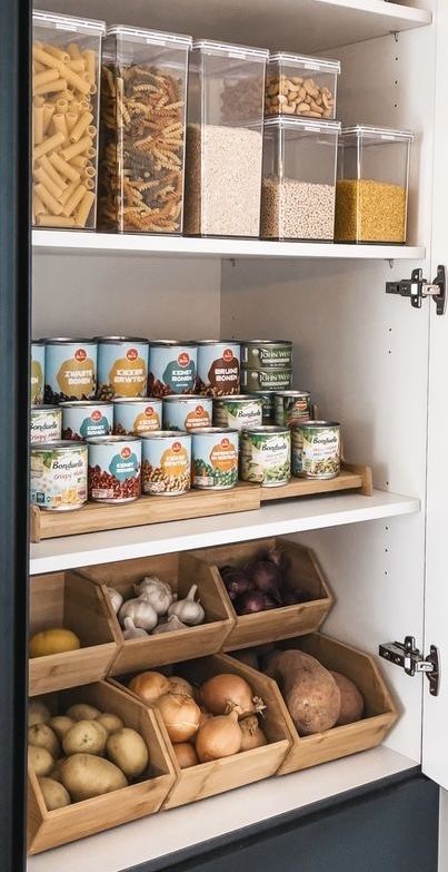 fcf4f308-5202-4809-83ce-ffda72d468b4 Organized pantry with containers of pasta, grains, canned goods, and fresh vegetables in wooden baskets. | Sky Rye Design Organized pantry with containers of pasta, grains, canned goods, and fresh vegetables in wooden baskets.