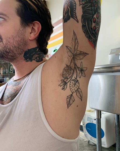 fd136ecd428da45af39bad66954935b6 Man with intricate strawberry tattoo under arm, showcasing body art in a casual setting. | Sky Rye Design Man with intricate strawberry tattoo under arm, showcasing body art in a casual setting.