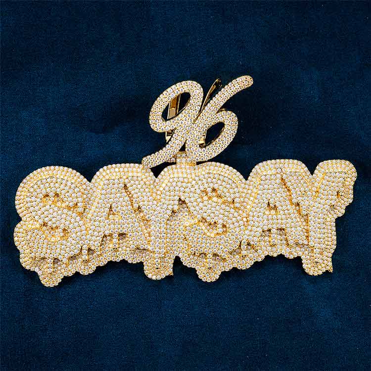 Gold and diamond-encrusted SAY SAY pendant with 96 design on dark blue background.