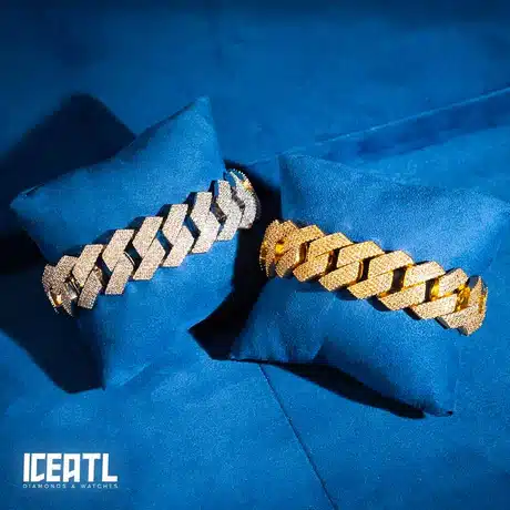 Gold and silver diamond-studded bracelets on blue pillows, displayed by IceATL Diamonds & Watches.
