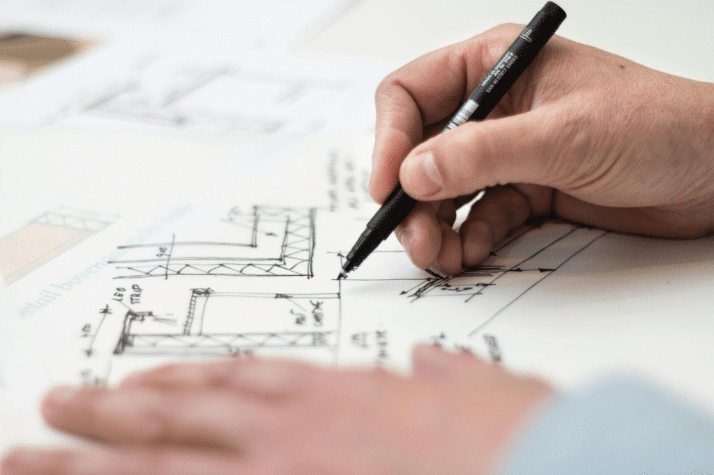 Hand drawing architectural plans with a black pen, focusing on precision and design details.