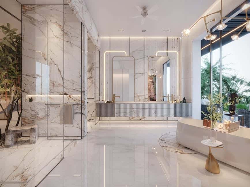 image Luxurious marble bathroom with glass shower, modern lighting, and a sleek bathtub near a large window with greenery. | Sky Rye Design Luxurious marble bathroom with glass shower, modern lighting, and a sleek bathtub near a large window with greenery.