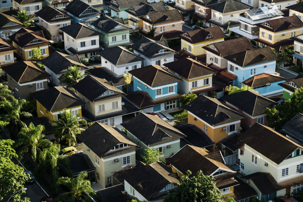 Aerial view of colorful suburban houses with gardens and palm trees, creating a vibrant residential neighborhood setting.