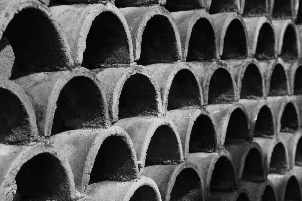 Close-up of stacked concrete pipes forming a geometric pattern in black and white.