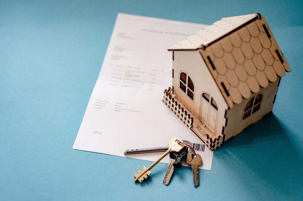 image Miniature house with keys on a mortgage document, symbolizing home ownership and real estate investment. | Sky Rye Design Miniature house with keys on a mortgage document, symbolizing home ownership and real estate investment.