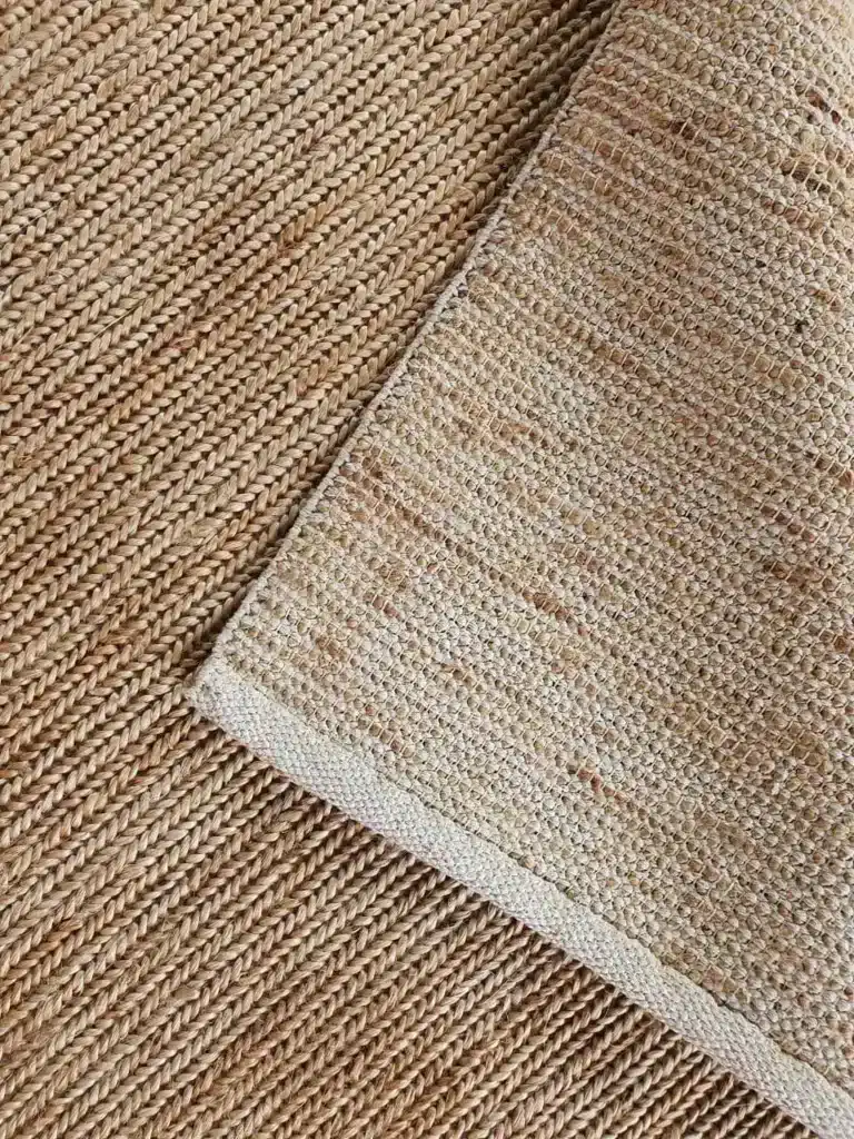 image_4_1024x Close-up of a textured beige woven jute rug, showcasing the intricate details and craftsmanship on its surface. | Sky Rye Design Close-up of a textured beige woven jute rug, showcasing the intricate details and craftsmanship on its surface.