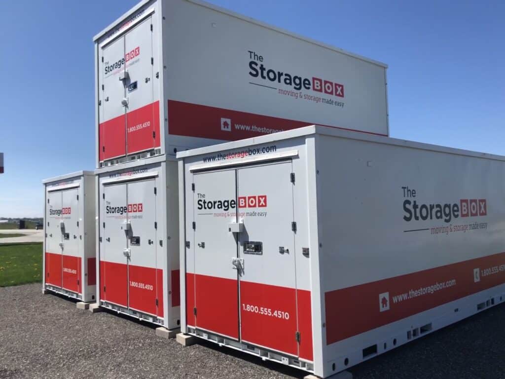 img_e5684-1 Stacked white and red storage boxes labeled The Storage Box outdoors on a clear day. | Sky Rye Design Stacked white and red storage boxes labeled The Storage Box outdoors on a clear day.