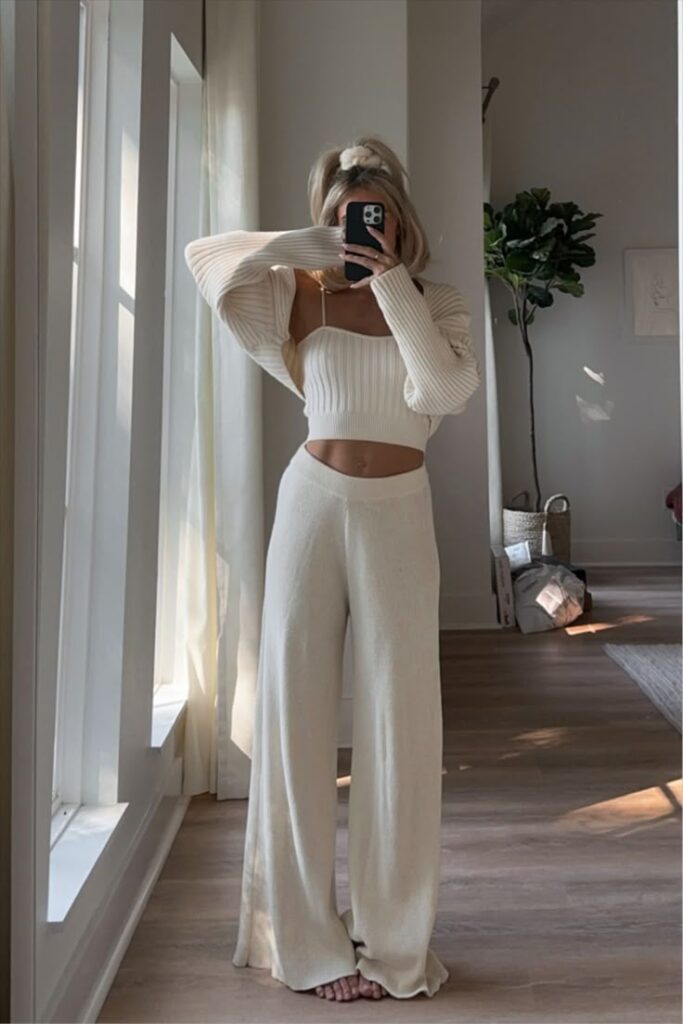 joandkemp on LTK Woman in a cozy white outfit takes a mirror selfie in a sunlit room with plant decor. | Sky Rye Design Woman in a cozy white outfit takes a mirror selfie in a sunlit room with plant decor.