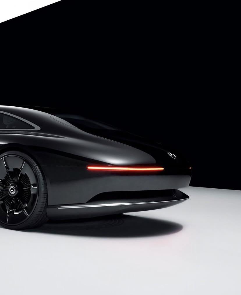 mercedes-benz-reveals-the-vision-iconic-concept-v0-b1tktek3n2vf1 Sleek black luxury car with futuristic design and illuminated rear lights on a minimalist background. | Sky Rye Design Sleek black luxury car with futuristic design and illuminated rear lights on a minimalist background.