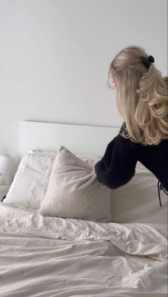 minimalist bedroom vibes 🤍 Person arranging pillows on a neatly made bed in a cozy, minimalist bedroom. | Sky Rye Design Person arranging pillows on a neatly made bed in a cozy, minimalist bedroom.