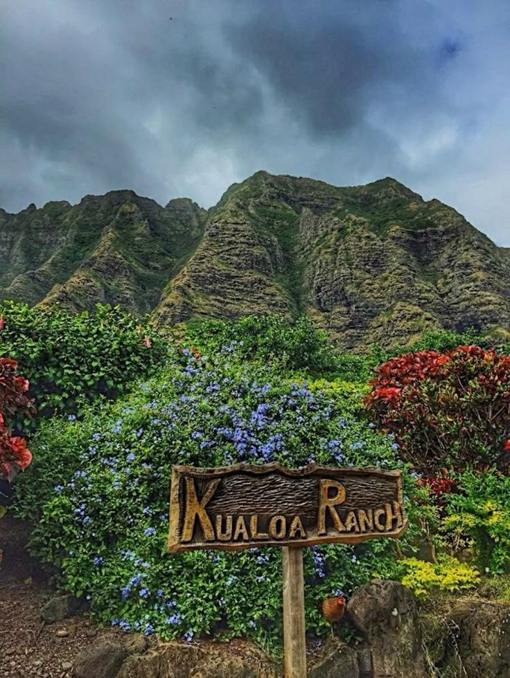 Kualoa Ranch scenic landscape with lush greenery and mountain backdrop under a cloudy sky in Oahu, Hawaii.