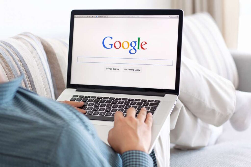 pandasecurity-google-malware-1100x733 Person using laptop with Google search page open while sitting on a couch. | Sky Rye Design Person using laptop with Google search page open while sitting on a couch.