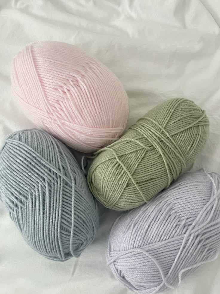 pastel yarn Pastel yarn balls in pink, green, blue, and lavender on a white fabric background, perfect for knitting and crafts. | Sky Rye Design Pastel yarn balls in pink, green, blue, and lavender on a white fabric background, perfect for knitting and crafts.