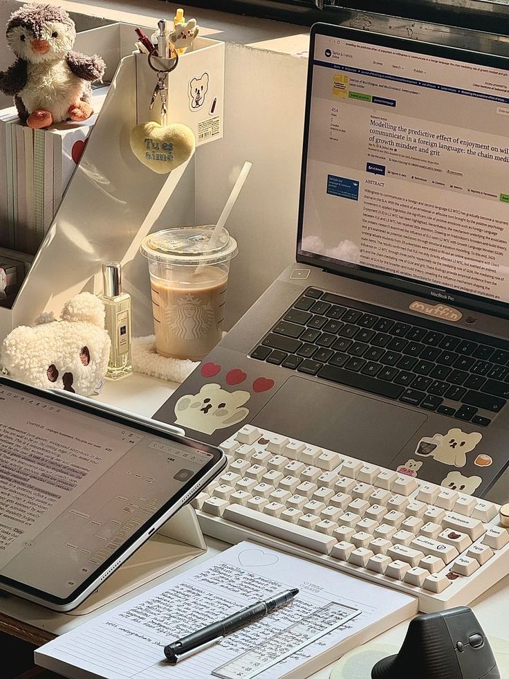 rsthbarethbae Cozy study desk with laptop, tablet, coffee, and notes. Plush toys add a cute touch to the organized workspace. | Sky Rye Design Cozy study desk with laptop, tablet, coffee, and notes. Plush toys add a cute touch to the organized workspace.