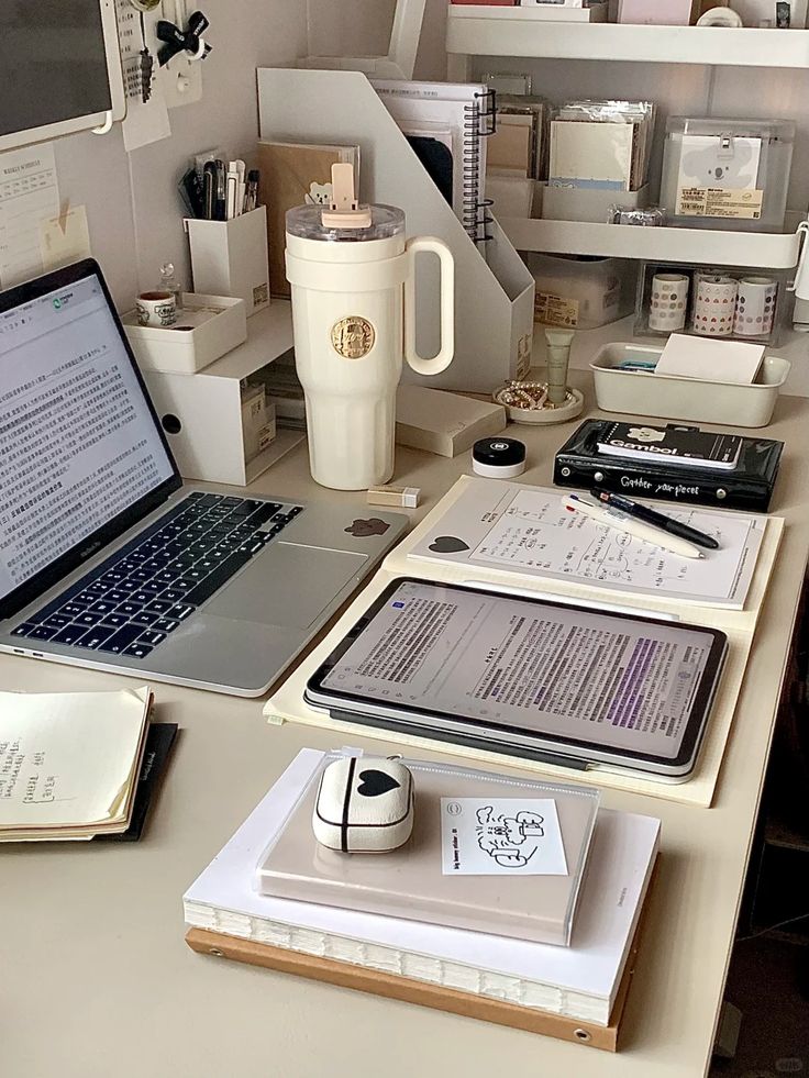 srhbethbgra Organized study desk with laptop, tablet, notebooks, stationery, and a large coffee mug for productivity. | Sky Rye Design Organized study desk with laptop, tablet, notebooks, stationery, and a large coffee mug for productivity.