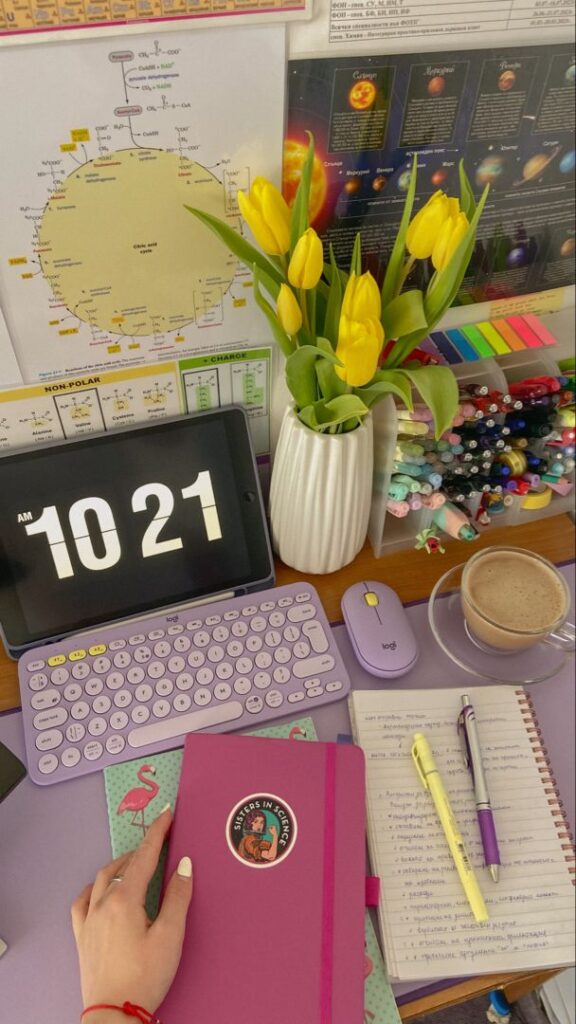 study atmosphere 👏🏻 Colorful study desk with purple keyboard, yellow tulips, stationery, and a tablet displaying time at 10:21 AM. | Sky Rye Design Colorful study desk with purple keyboard, yellow tulips, stationery, and a tablet displaying time at 10:21 AM.