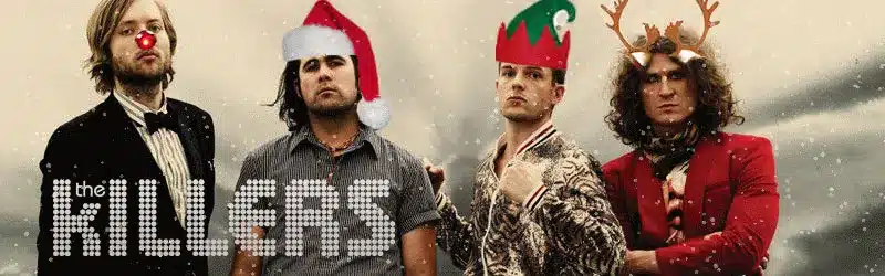 Four men wearing festive holiday hats with snow, and The Killers logo in the foreground.