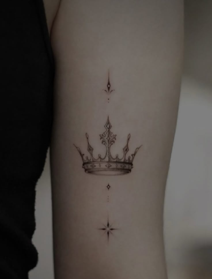 _ Intricate crown tattoo on arm, with minimalist star designs above and below. Elegant and detailed ink art. | Sky Rye Design Intricate crown tattoo on arm, with minimalist star designs above and below. Elegant and detailed ink art.