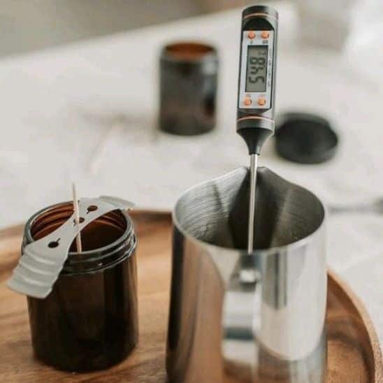 _ Candle making setup with digital thermometer in metal pitcher and wick in jar, ideal for DIY crafts and home decor. | Sky Rye Design Candle making setup with digital thermometer in metal pitcher and wick in jar, ideal for DIY crafts and home decor.